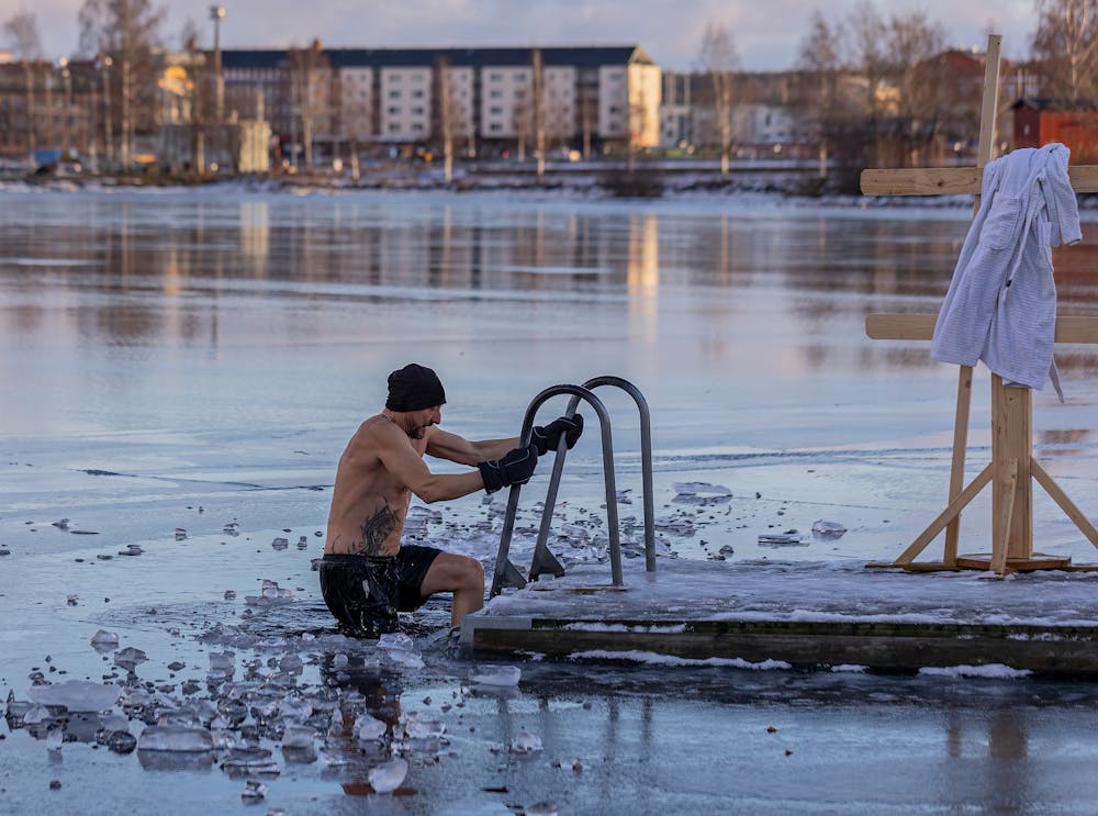 homme pratiquant le bain froid dans un lac gelé pour réduire le cortisol et le stress
