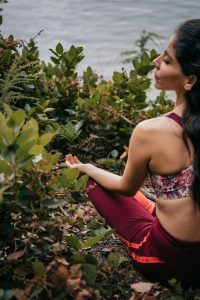 femme méditant au bord d'une rivière froide pratique bain froid et méditation