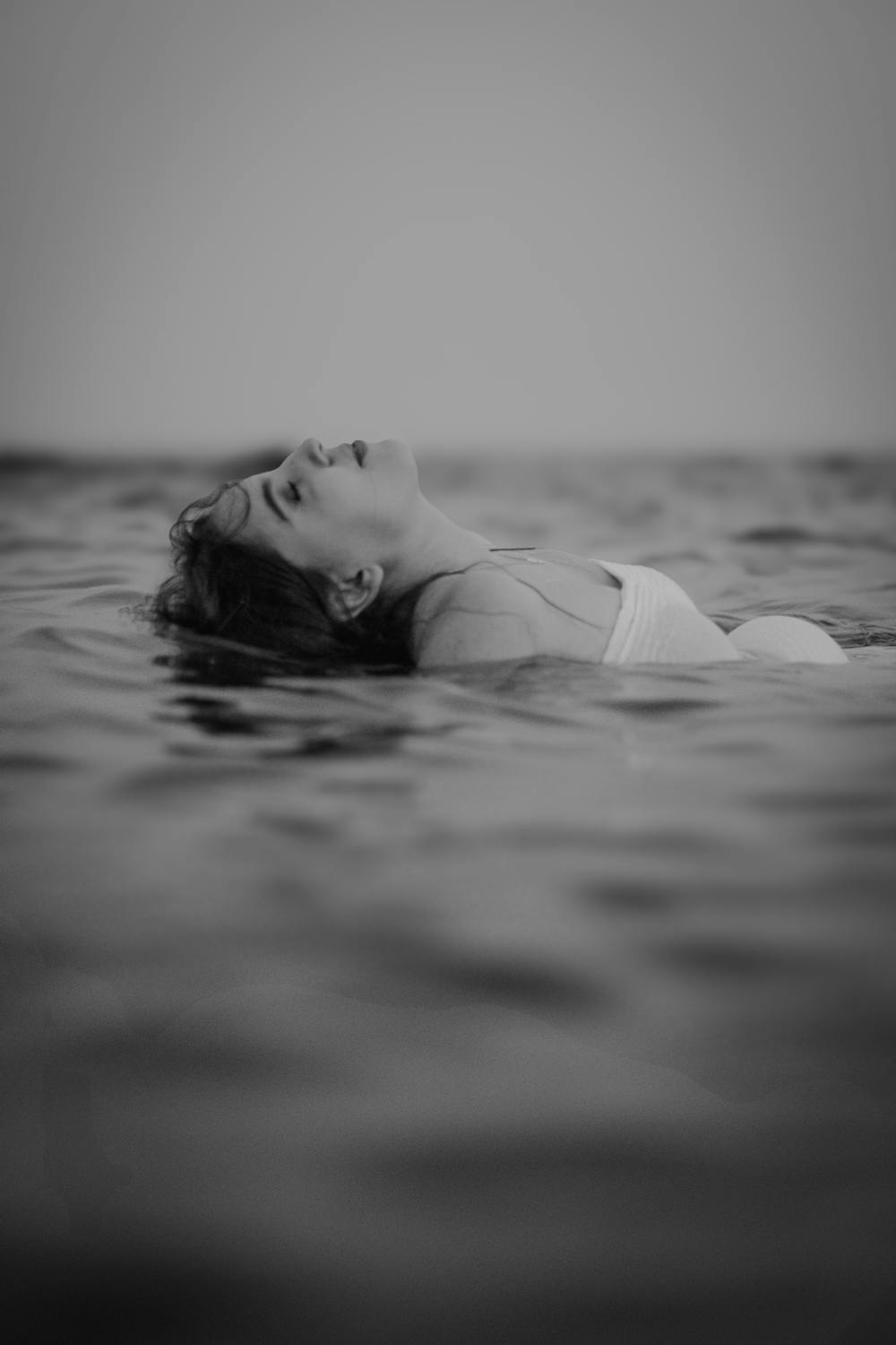 Femme flottant dans une eau calme, symbolisant les effets apaisants du bain froid sur la dépression