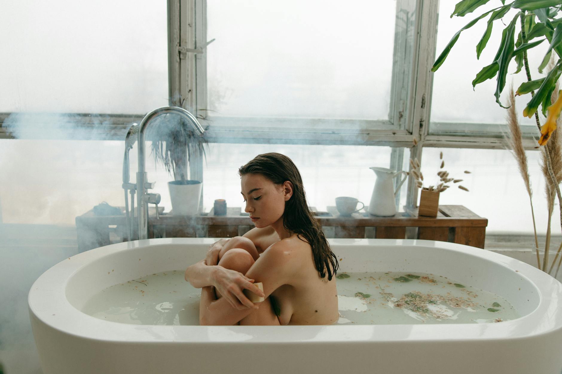 Woman in a tranquil indoor setting, embracing self-care with a peaceful bath.