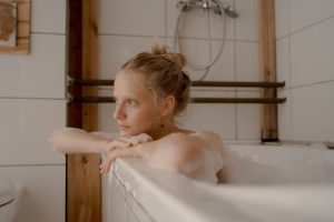 A peaceful moment of relaxation in a bathtub with natural light and soothing bubbles.