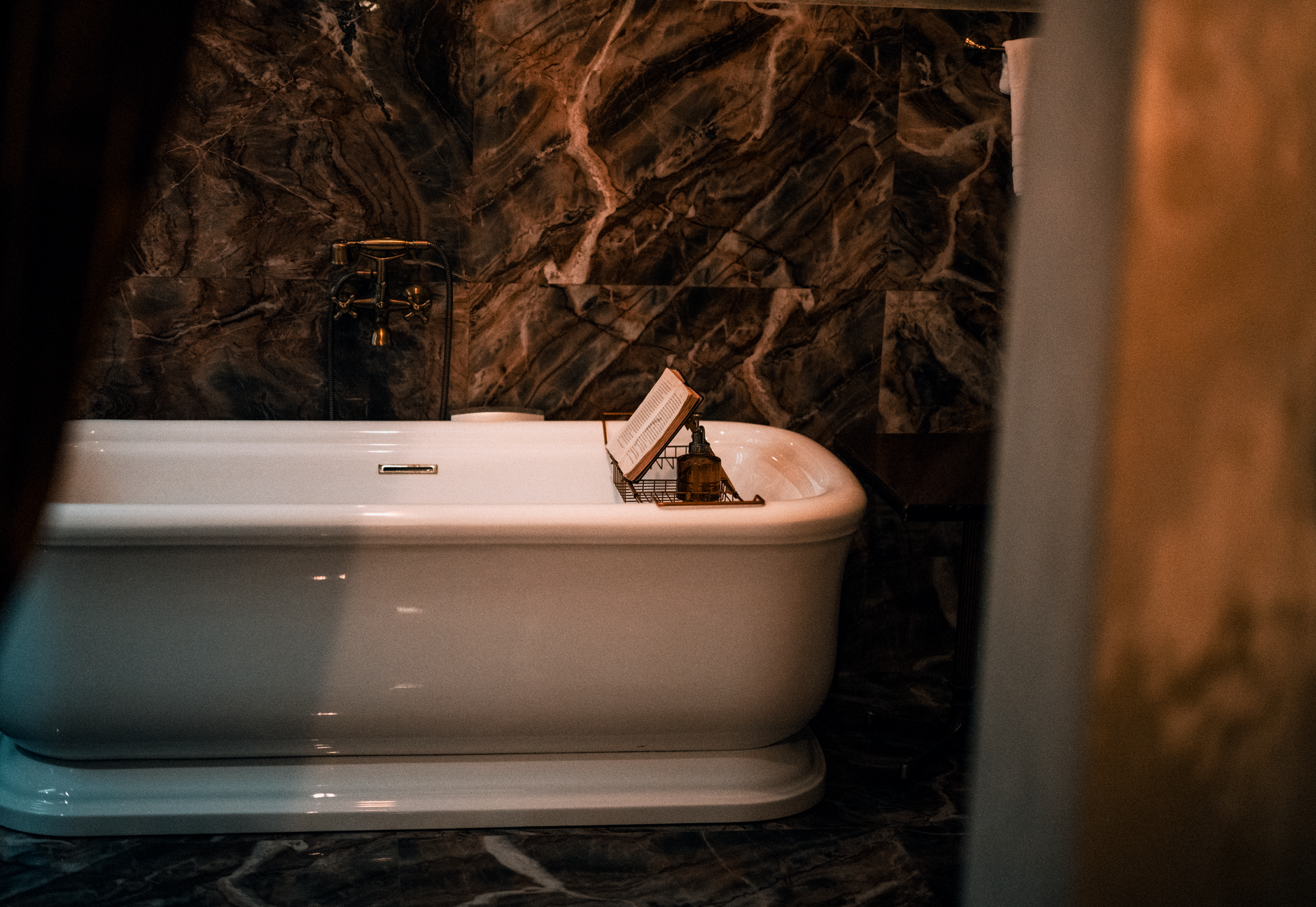 Luxurious bathroom featuring a classic white bathtub against elegant marble walls, creating a serene ambiance.