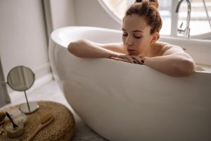 Woman enjoying a serene bath, focusing on relaxation and self-care at home.